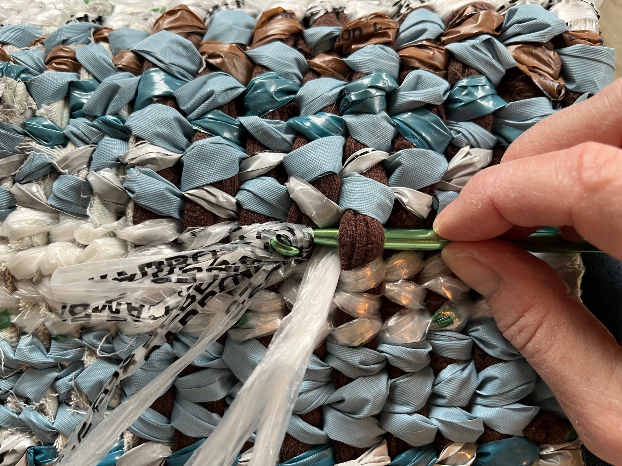 weaving on loom with plastic and fabric.