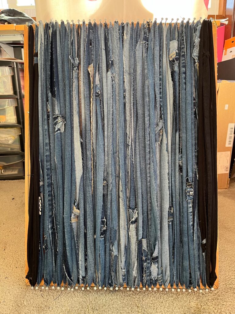 Nail loom with strips of denim as the warp