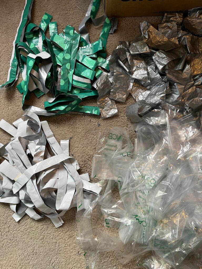 Four piles of plastic strips - green, silver, clear and white